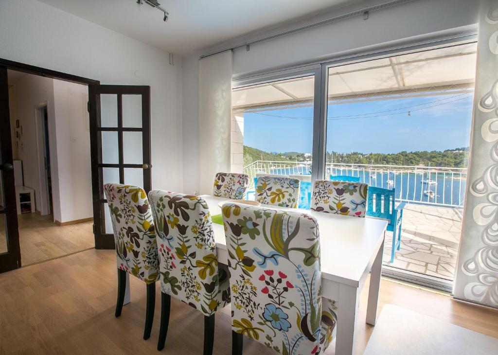 科尔丘拉Truly Mediterranean Apartment "Spark"的一间带桌椅和大窗户的用餐室