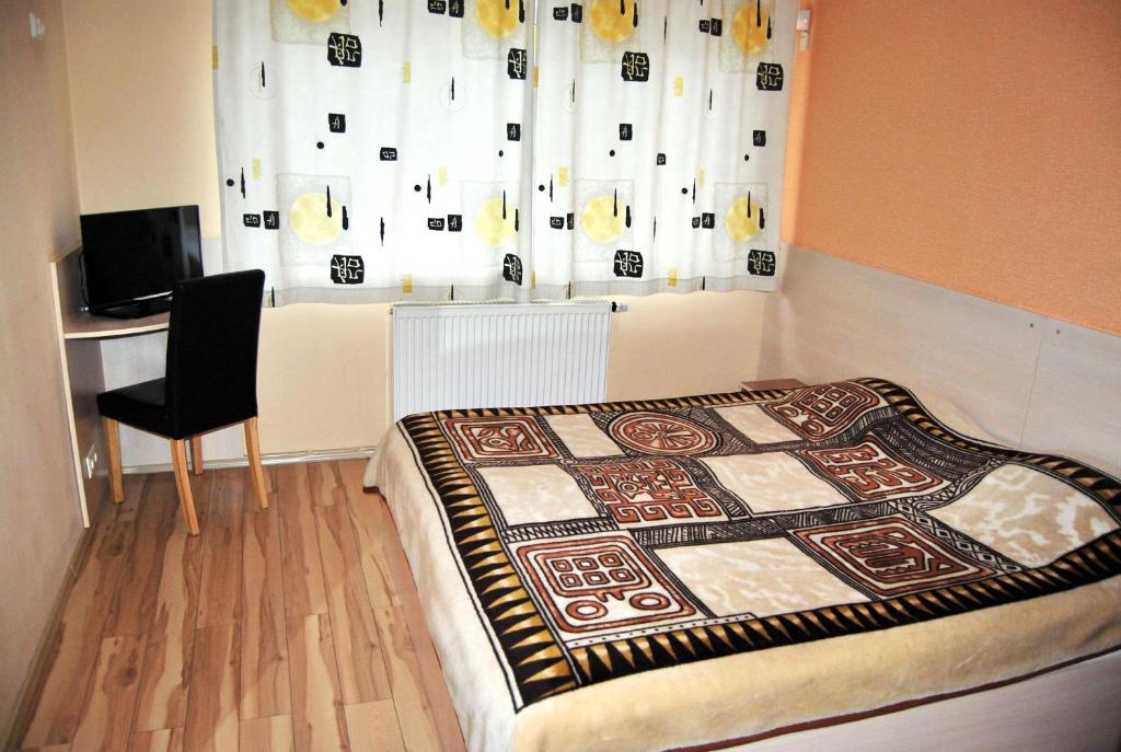 希奥利艾Kambarių nuoma - Šiauliai SAURIDA的卧室配有床、椅子和窗户。