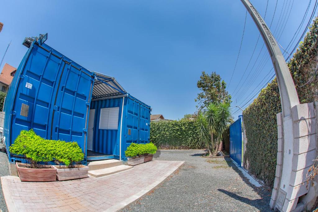 坎皮纳斯Residencial Villa Container的 ⁇ 旁的蓝色房子,有盆栽植物