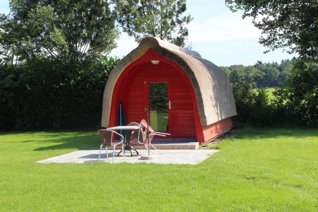 Drijber波德露营地的红色的圆顶房子,在草地上配有桌椅