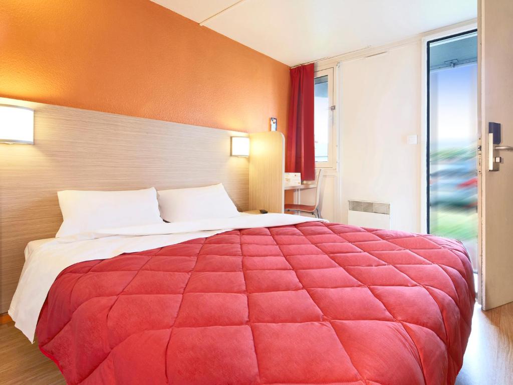 布雷西尔乐趣普瑞米尔经典酒店的窗户客房内的一张红色大床
