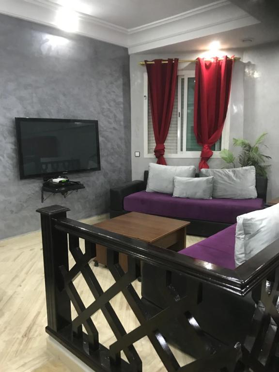 卡萨布兰卡卡萨布兰卡中心威乐公寓的客厅配有紫色沙发和电视