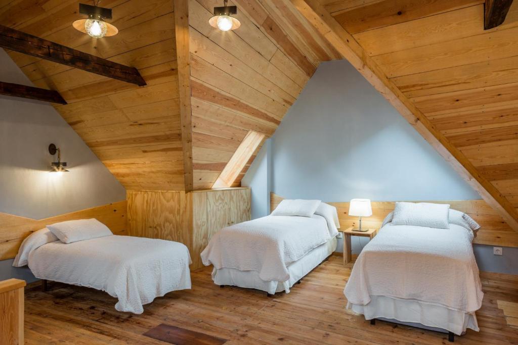贝特伦Casa Rural "Casa Chin", Val d'Aran的阁楼间设有两张床铺和木制天花板