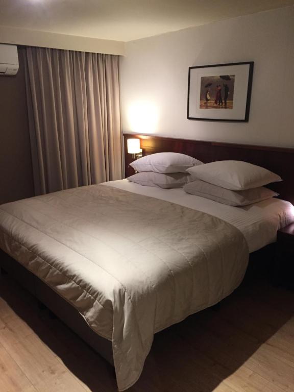 阿尔特Hotel Prélude的卧室配有一张带白色床单和枕头的大床。