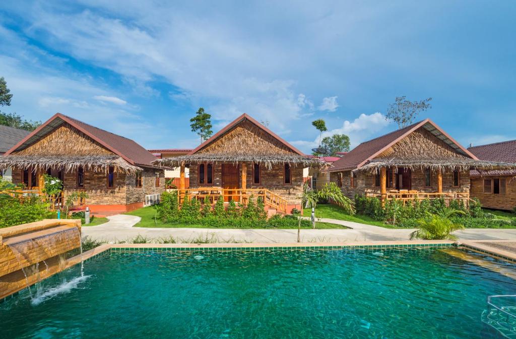 奥南海滩Pinthong Aonang Villa - FREE SHUTTLE SERVICE TO THE BEACH的两栋建筑前方带游泳池的房子