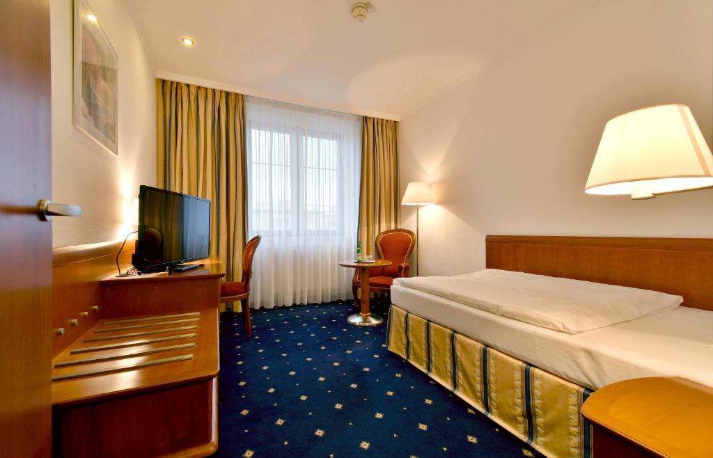 布拉格冠冕酒店的酒店客房,配有床和电视
