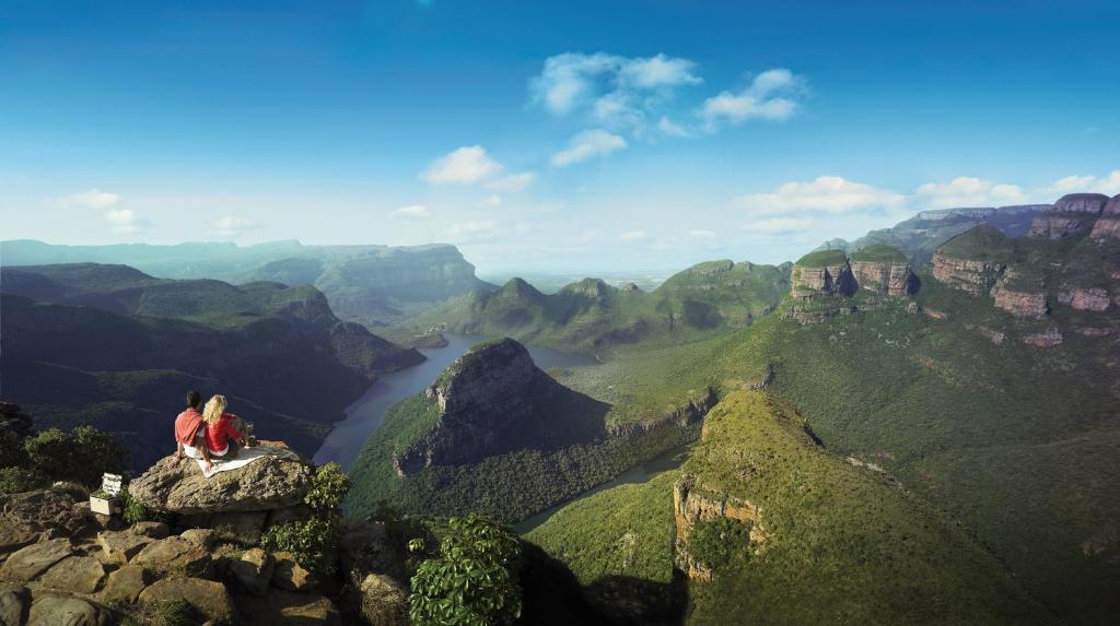 MatibidiBlyde Canyon, A Forever Resort的两人坐在山边,俯瞰着峡谷