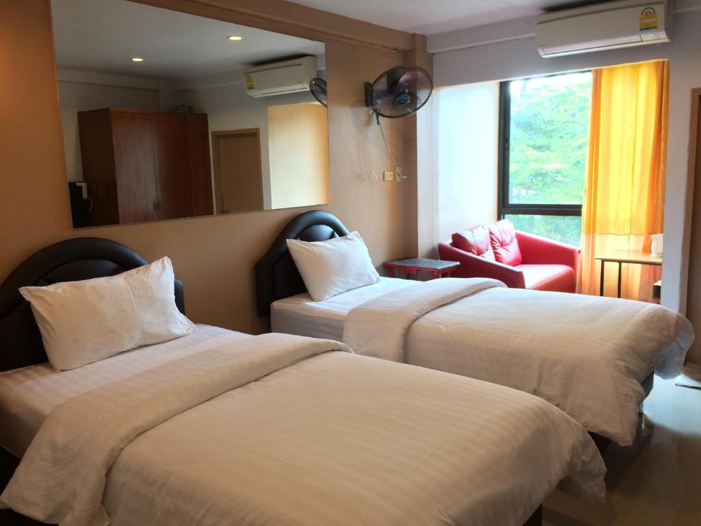 曼谷禅木安酒店的酒店客房,设有两张床和一张红色椅子