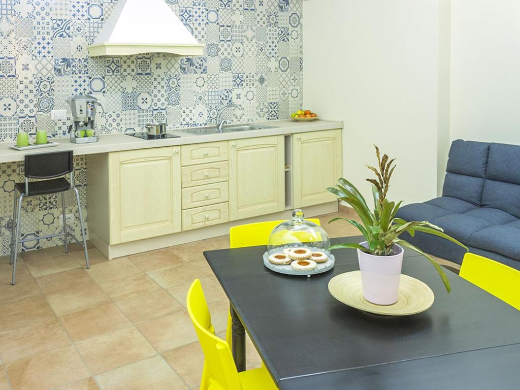 罗萨诺B&B Domus Purpurea的厨房里配有一张桌子,上面有盘子的食物