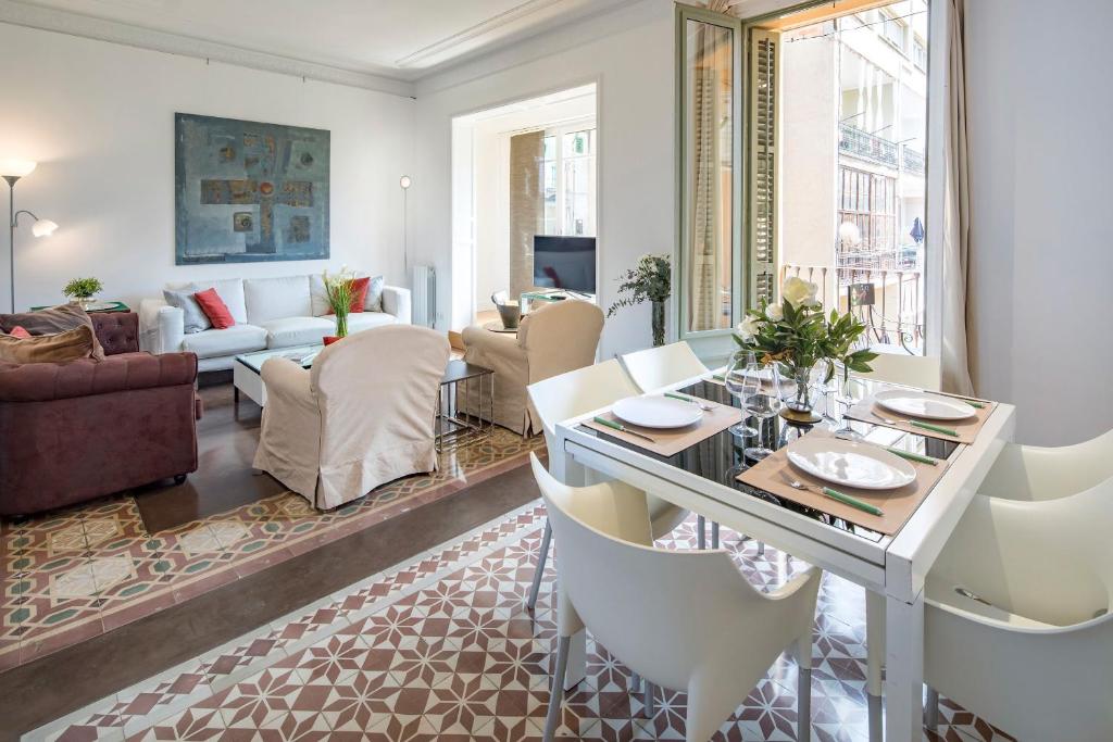 巴塞罗那花园景人居公寓的客厅配有桌子和白色椅子