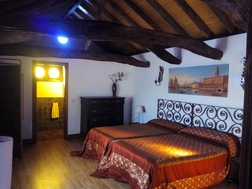 Villarrubia de SantiagoEl Sueño de Lucrecia的卧室配有一张床,墙上挂有绘画作品