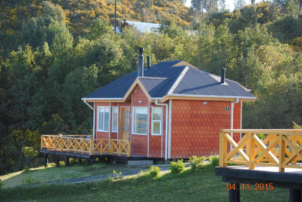 卡斯特鲁特拉延度假屋的山坡上带黑色屋顶的红色小屋