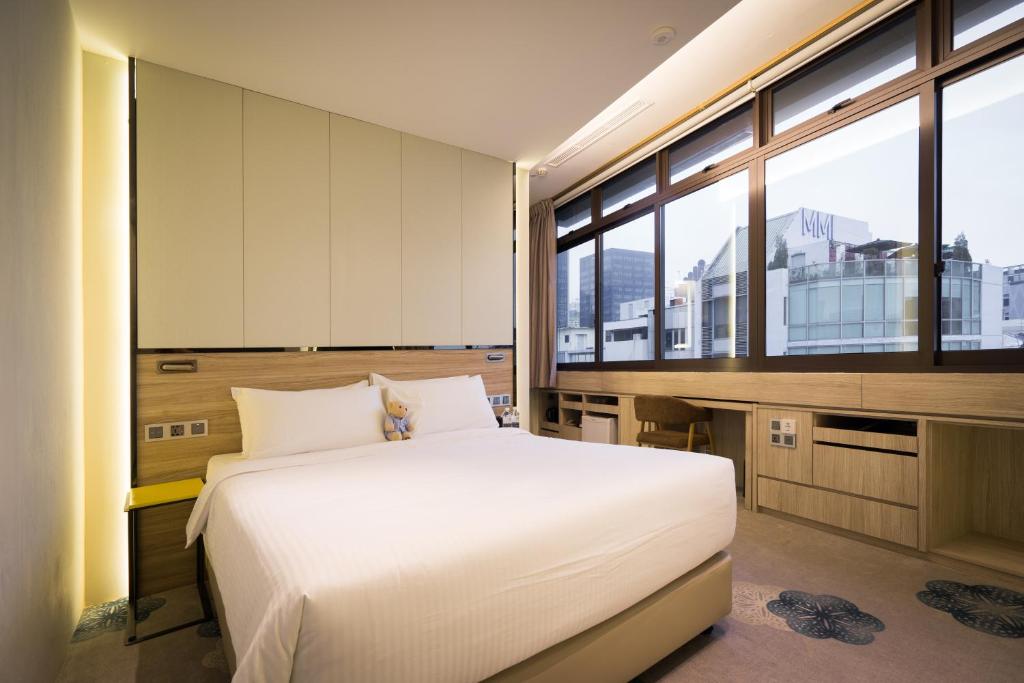 新加坡The Quay Hotel的卧室设有一张白色大床和大窗户
