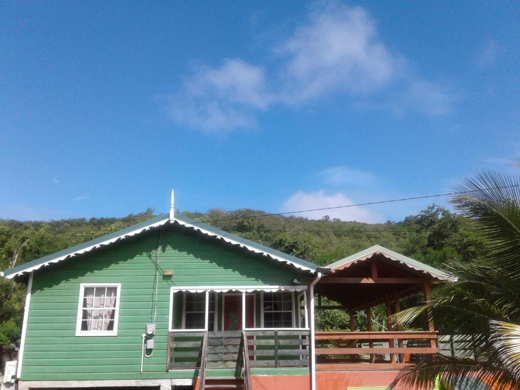 格罗斯岛Seawind Cottage- Traditional St.Lucian Style的一座绿色房子,上面有十字架