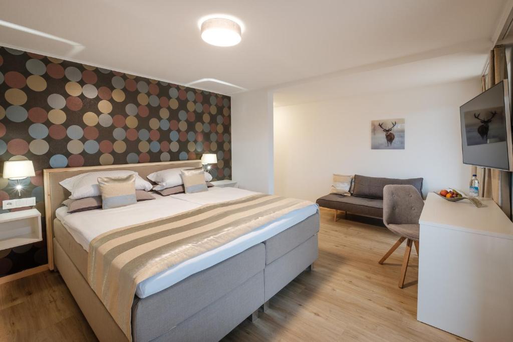 费斯恩索内胡格尔旅馆的一间卧室配有一张大床和一张沙发