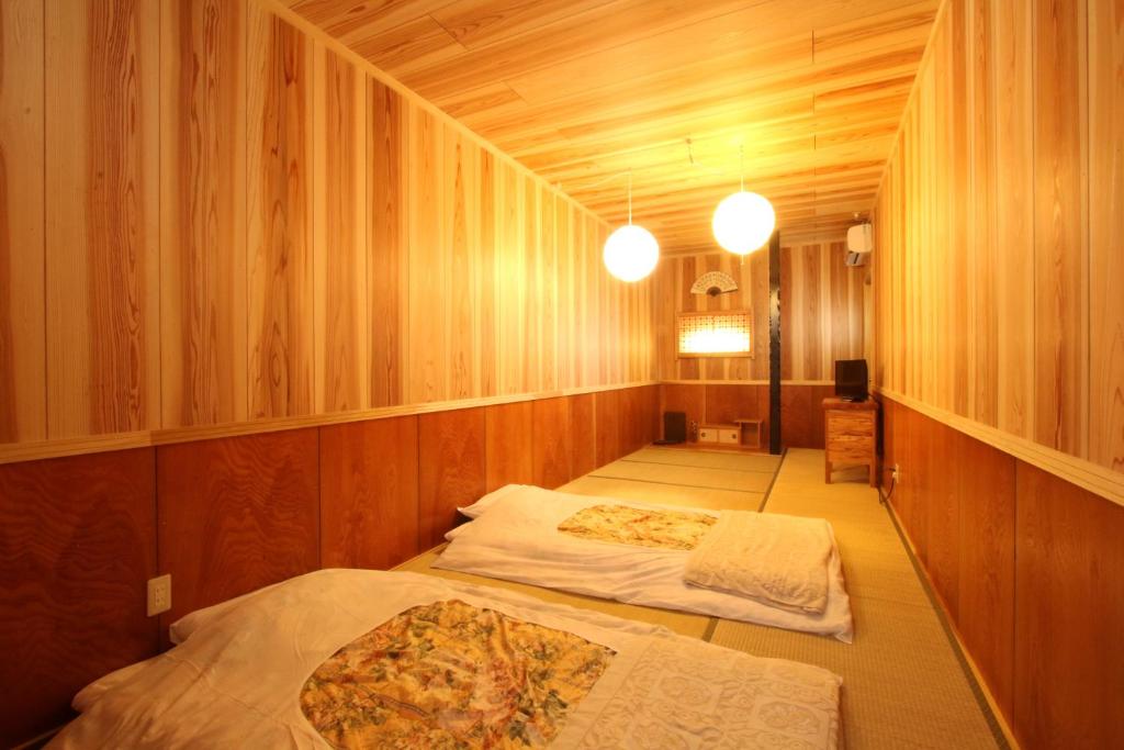 人吉壱休背包客19旅馆的木墙客房的两张床