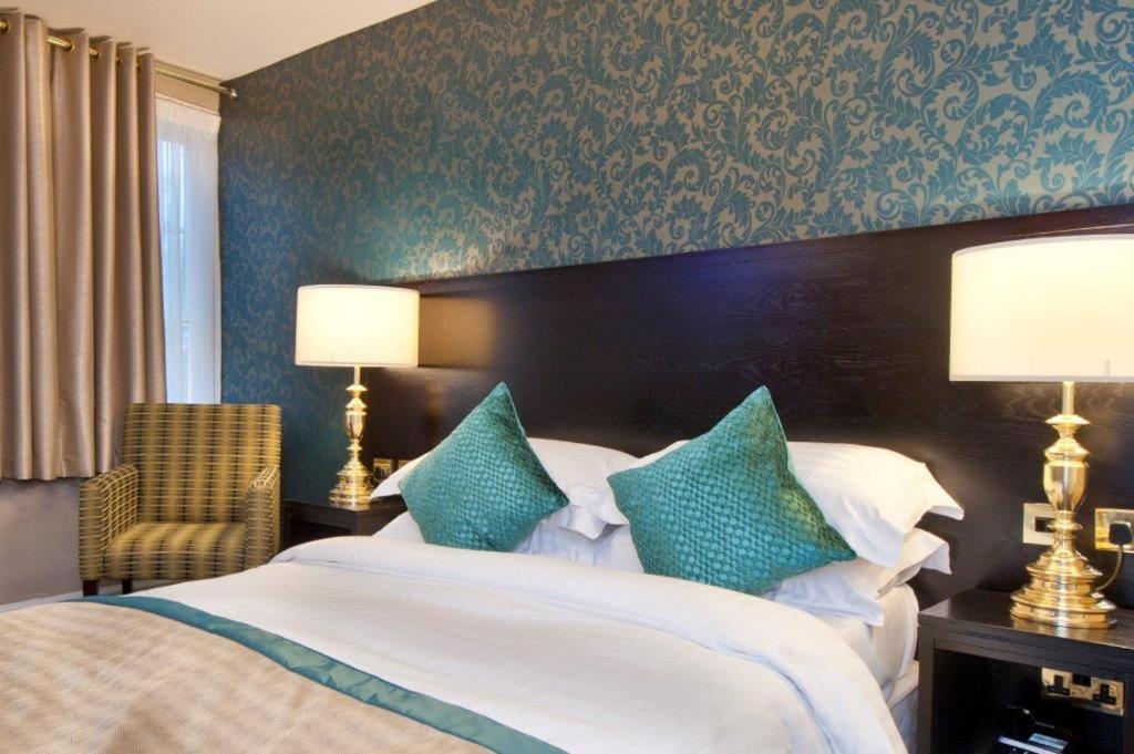 金斯林Globe Hotel Wetherspoon的一间卧室配有一张带蓝白色枕头的大床