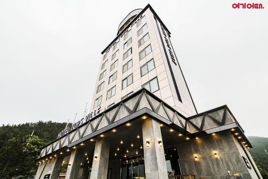 江陵市拓扑维尔酒店的一座高大的建筑,上面有灯