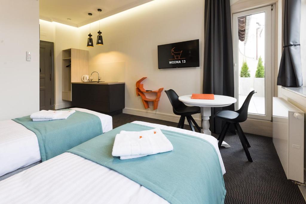 波兹南Apartamenty Wodna 13的酒店客房设有两张床和一张桌子。