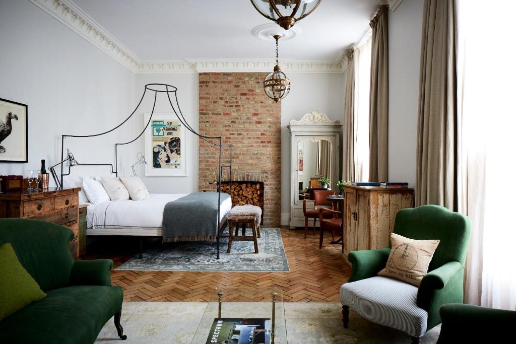 伦敦伦敦艺术家酒店的一间卧室配有一张床铺、椅子和一张桌子
