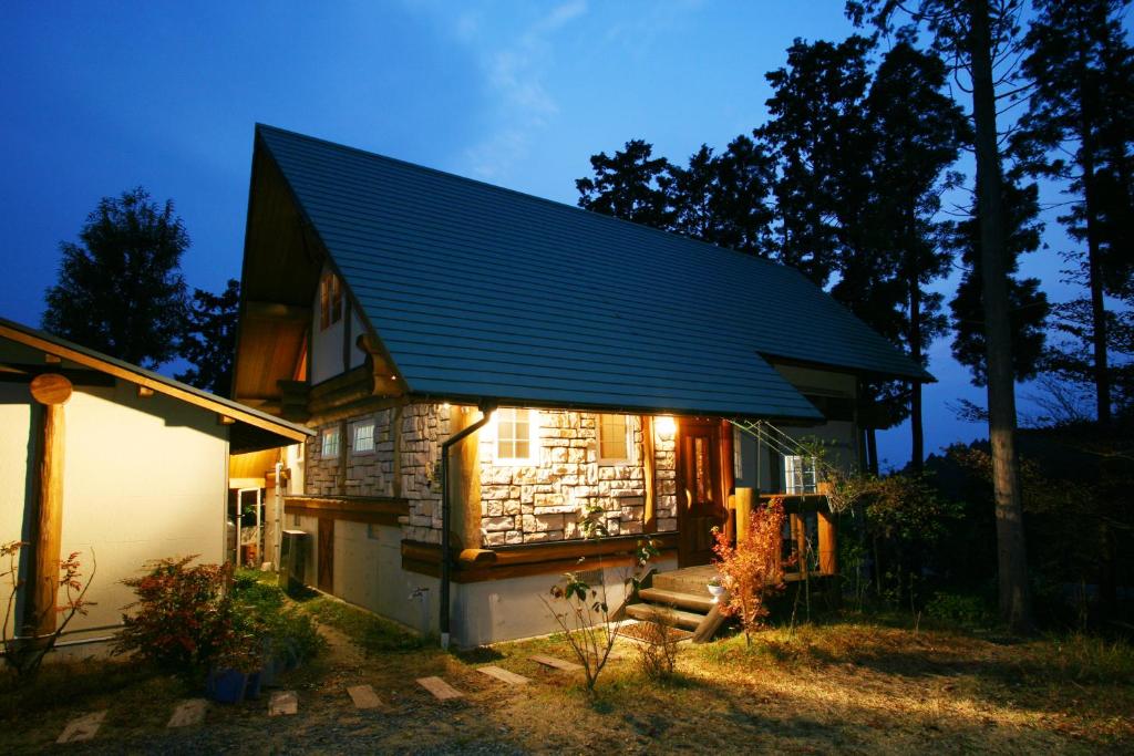 南小国町Kurokawa Mori no Cottage的蓝色屋顶的房屋,上面有灯