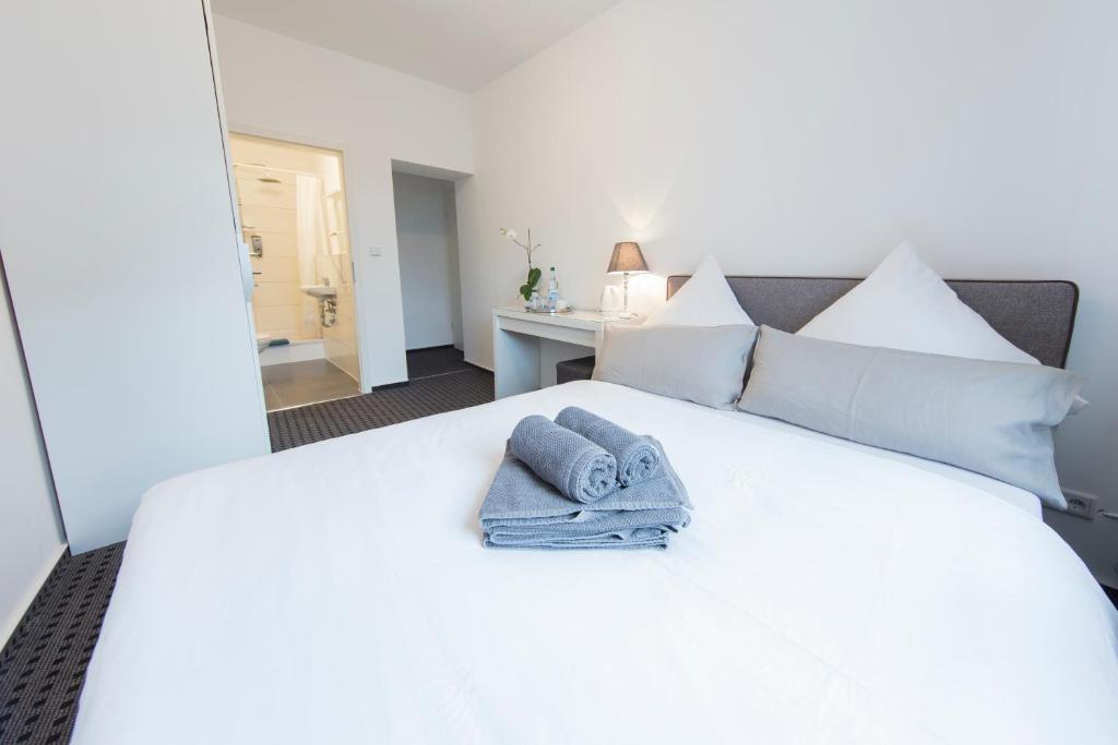 杜塞尔多夫贝罗里纳豪斯宾馆的卧室配有白色床和毛巾