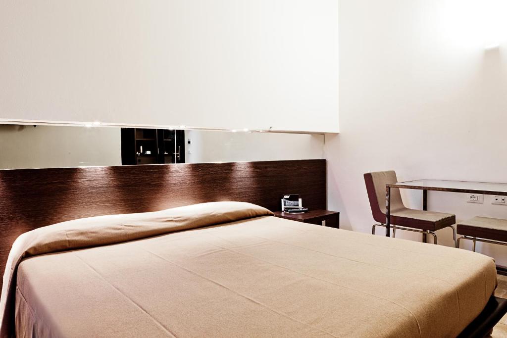 博洛尼亚穆亚酒店的卧室配有1张床、1张桌子和1把椅子