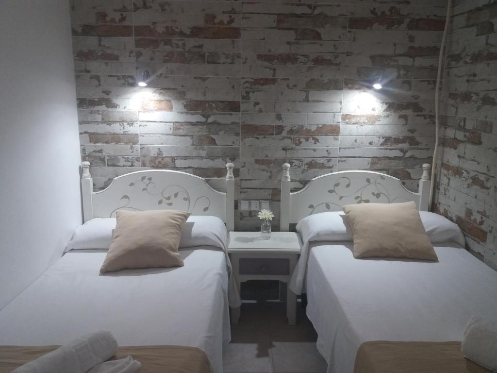 圣费尔南多Hospederia Islasol的砖墙间内的2张白色床