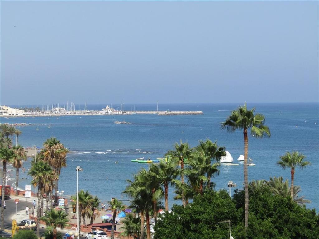 贝纳尔马德纳Luxury beachfront apartment in Benalmadena Costa的享有棕榈树海滩和大海的景色