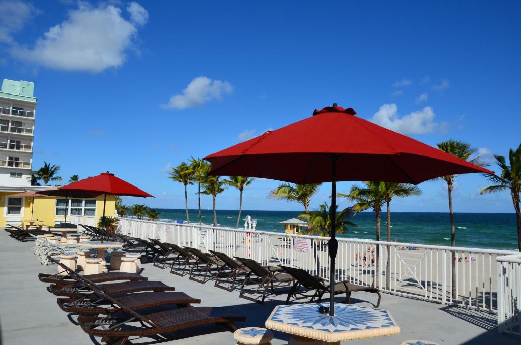 好莱坞La Terrace Oceanfront的海滩上的一排椅子和一把遮阳伞