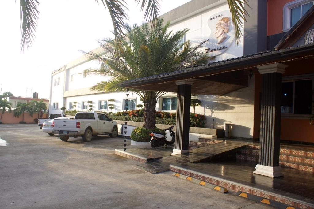 SabanetaGran Hotel Marien的停在大楼旁停车场的白色卡车