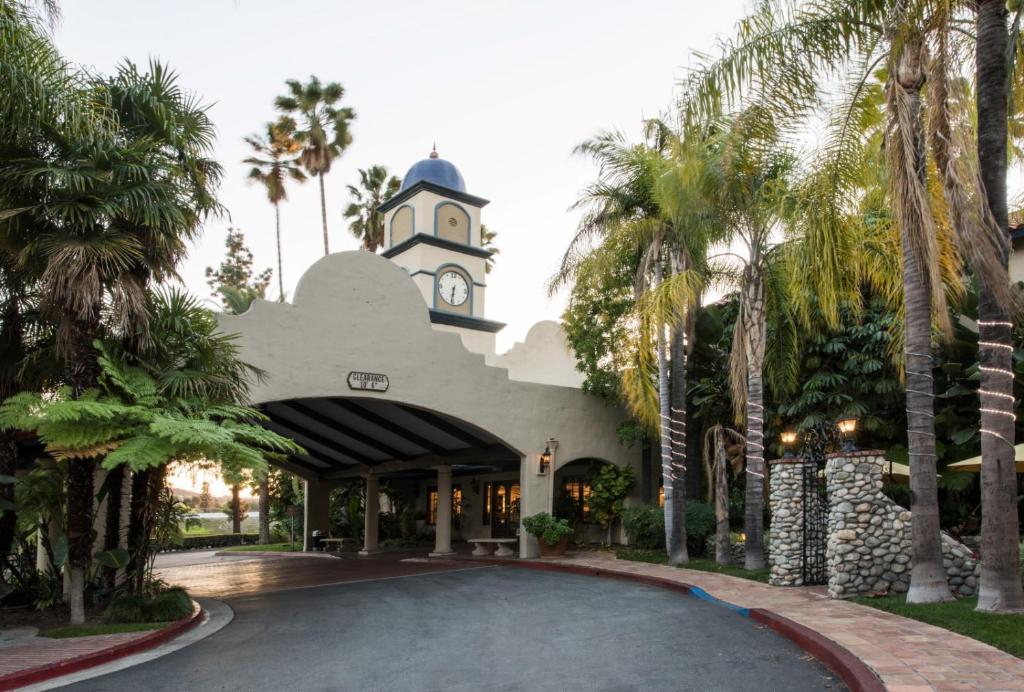 科维纳范莱酒店的一座拥有钟楼和棕榈树的建筑