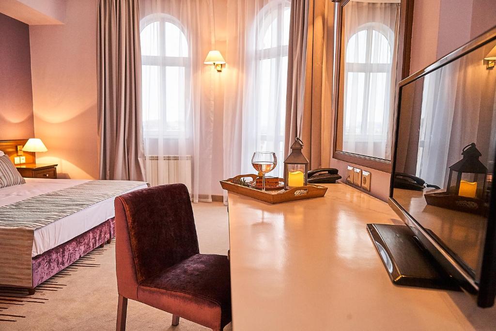 索非亚索非亚狮子酒店的酒店客房配有一张床、一张桌子和一把椅子。