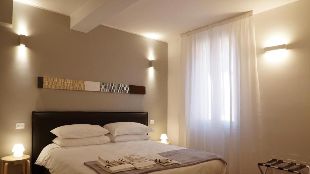 博洛尼亚Residenza Pellacani的卧室配有带白色枕头的床和窗户。