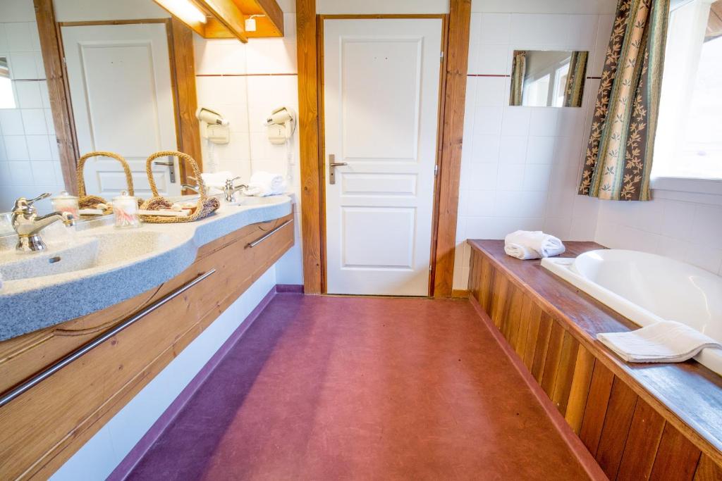 蒙乃第耶-勒潘Lautaret Lodge & Spa的浴室配有2个盥洗盆和1个浴缸。