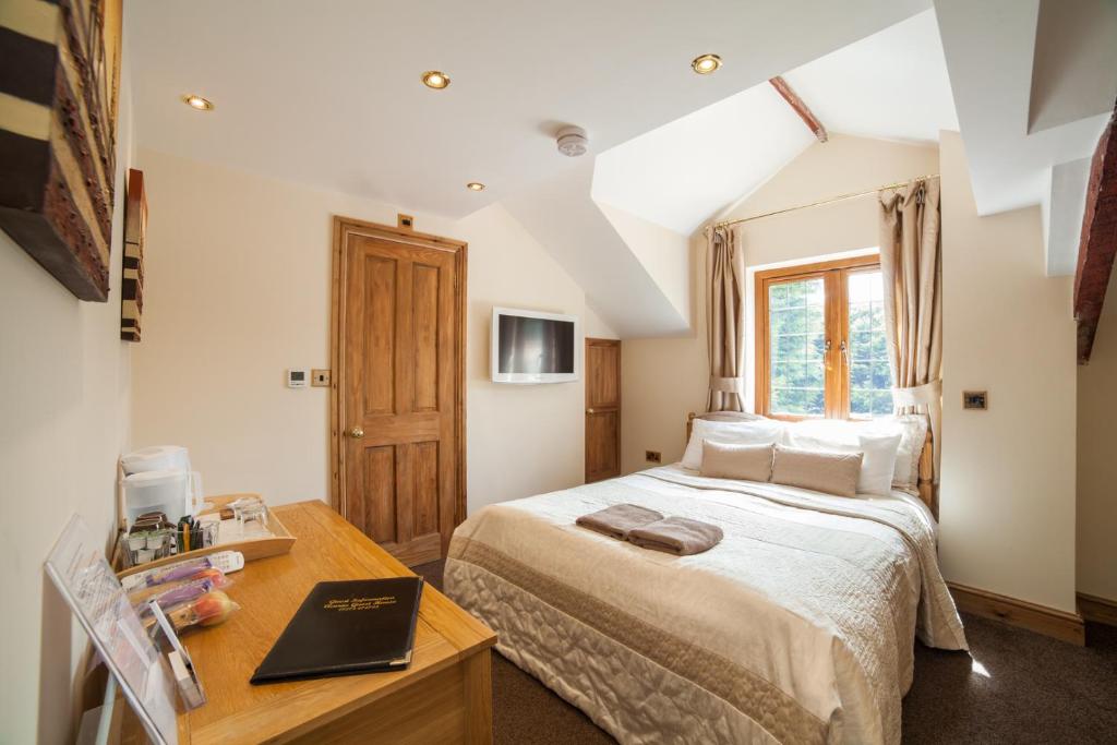 布里斯托Acorns Old Farm的一间卧室配有一张床、一张书桌和一个窗户。