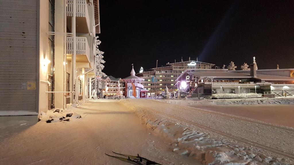 鲁卡Ruka Chalets Ski-Inn的夜间有建筑物和灯光的雪街道