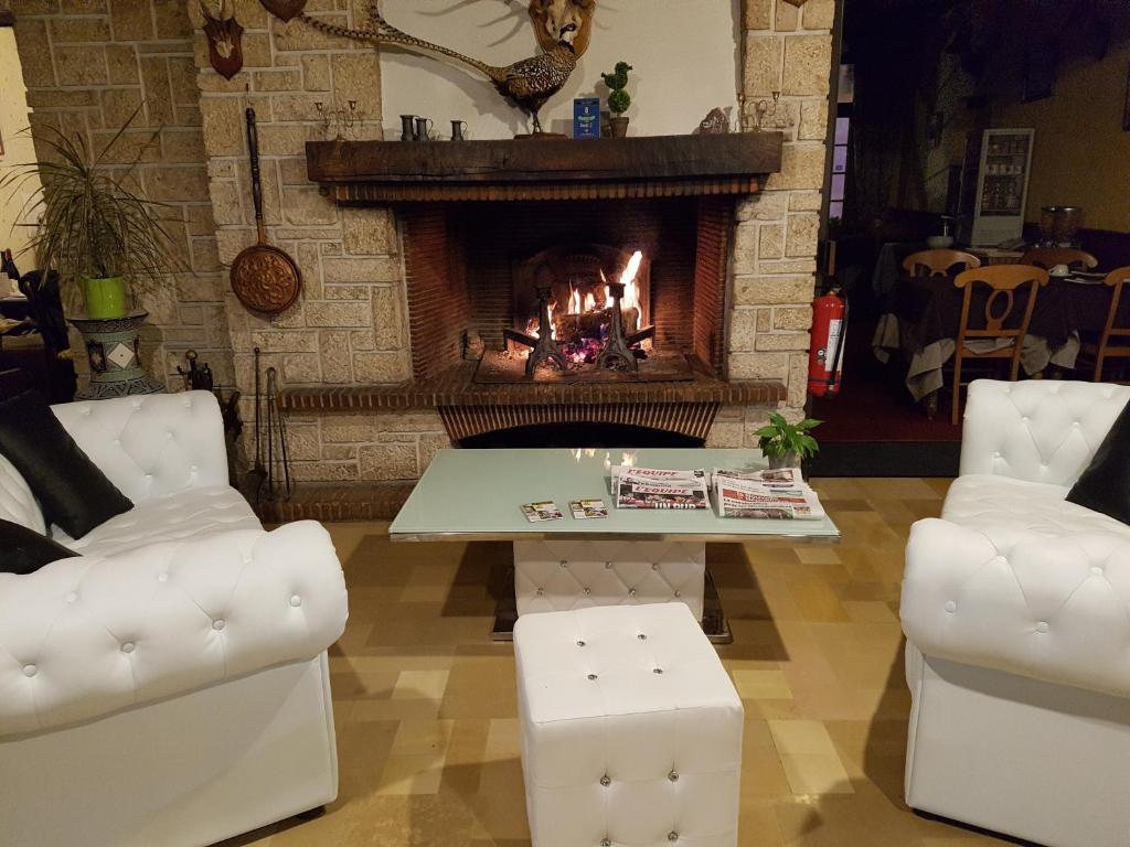 库谢韦尔尼圣休伯特酒店的客厅设有壁炉、桌子和椅子