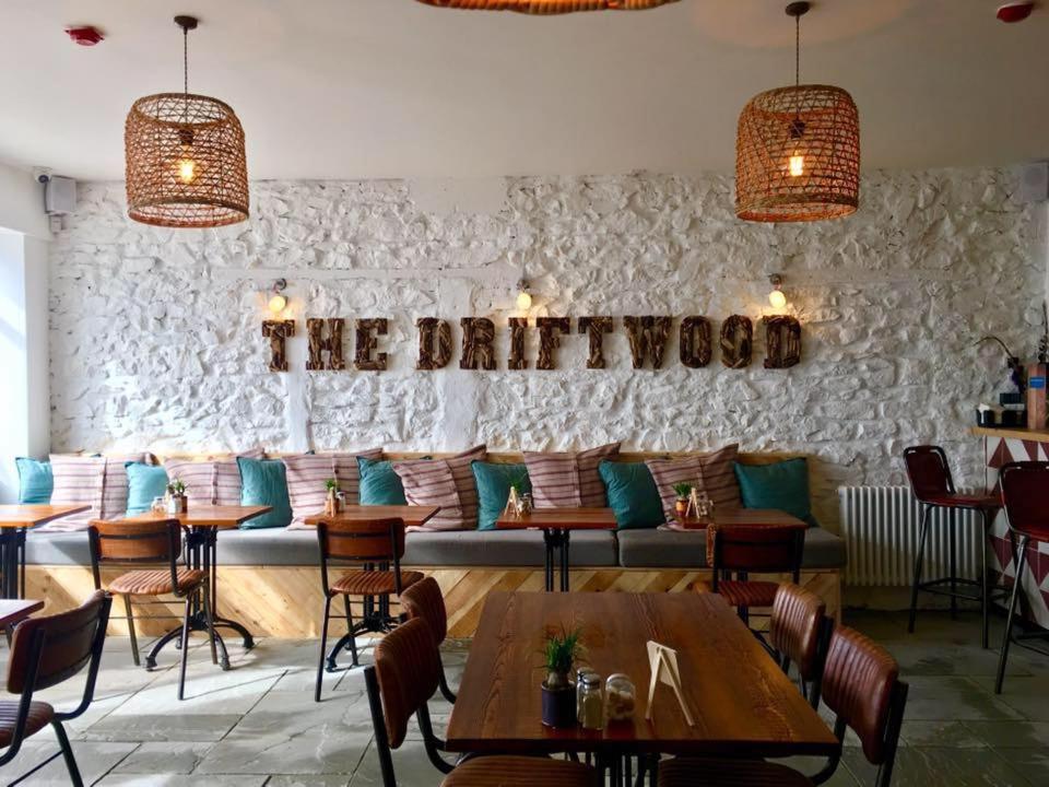 斯莱戈The Driftwood的餐厅设有桌椅和沙发。