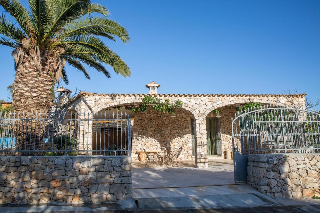 莱乌卡Villa Pietra Incantata的一座棕榈树和大门的建筑