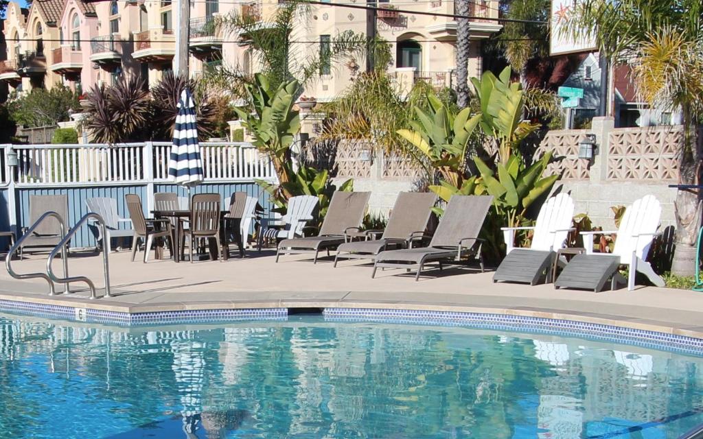 圣克鲁兹厄齐沃特海滩套房酒店的一座带桌椅的游泳池以及一座建筑