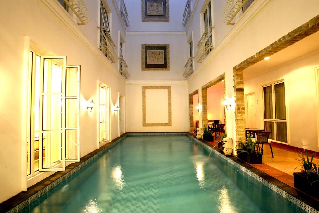 雅加达Sun Rise House的一座带游泳池的大楼内的室内游泳池