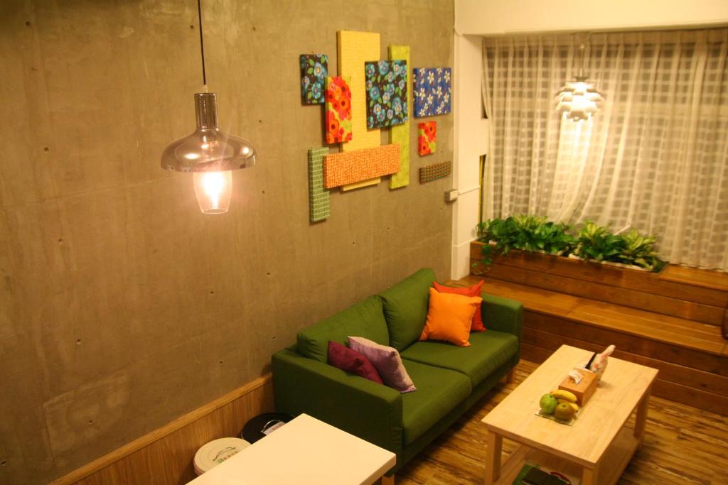台南友爱部屋 的客厅配有绿色沙发和桌子