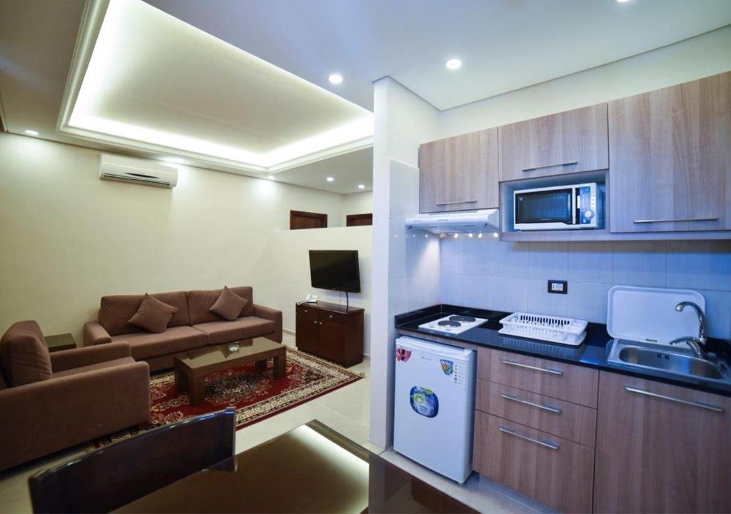 贝鲁特Al Jawhara Suites的厨房以及带沙发和炉灶的客厅。