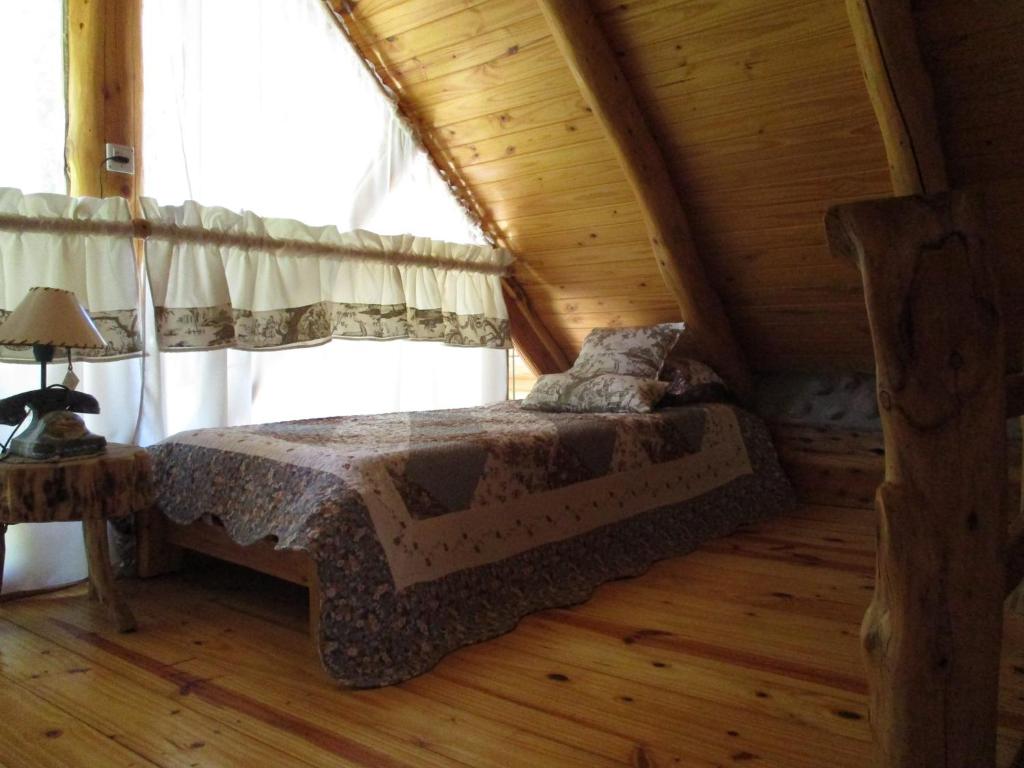 圣卡洛斯-德巴里洛切Paraiso Bariloche的小木屋内一间卧室,配有一张床