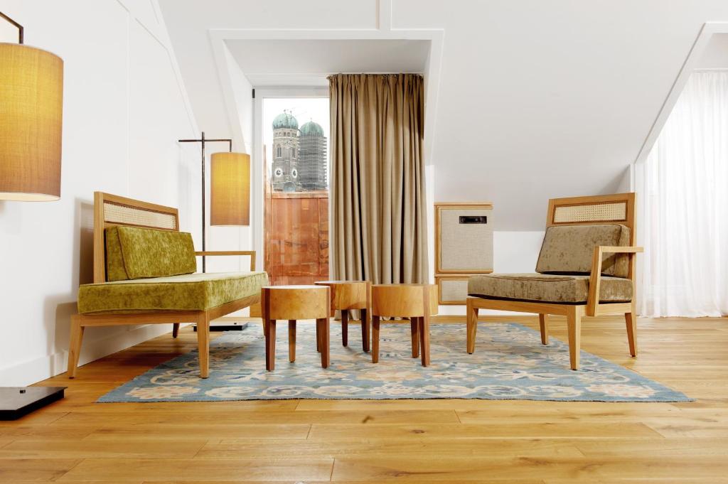慕尼黑路易斯酒店的客厅配有两把椅子和一张桌子