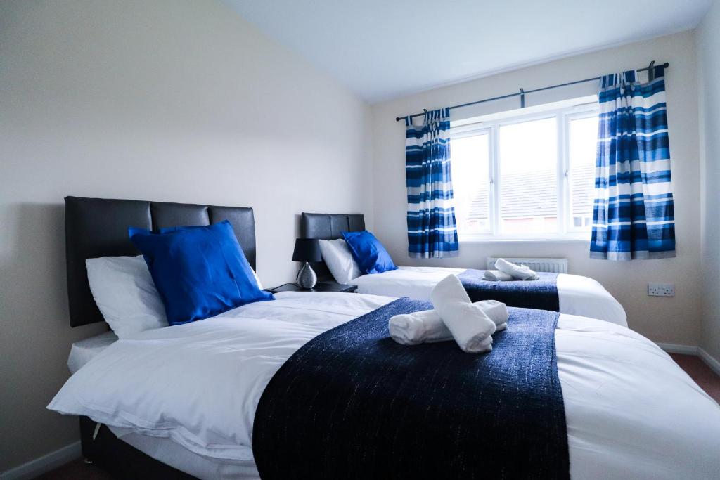 威森肖Royal Oak Home的卧室设有两张蓝色和白色的床