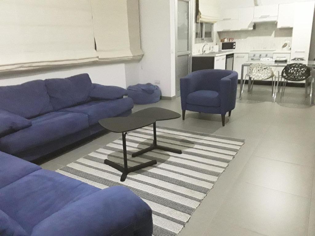 尼科西亚Julia's Residence的客厅配有蓝色的沙发和2把蓝色的椅子