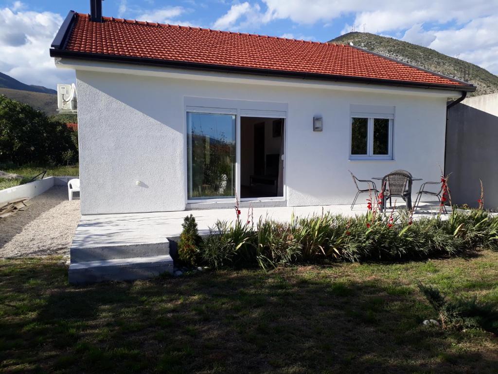 莫斯塔尔Little Mostar house的一间白色的小房子,有红色的屋顶