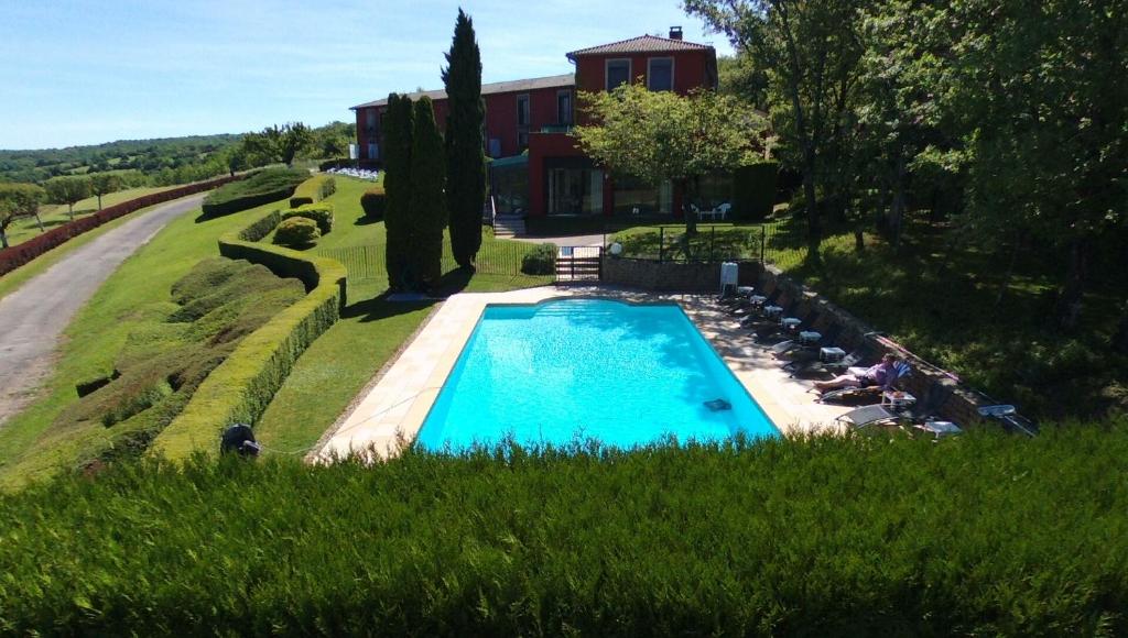 马赫伊列邦斯恩Hôtel Restaurant La Montagne De Brancion的一座房子旁的院子内的游泳池